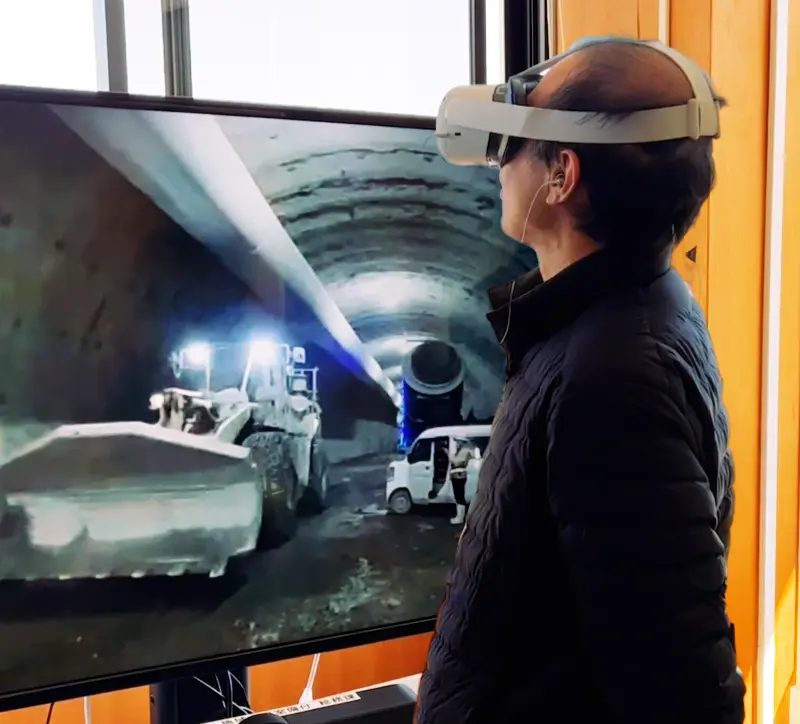 A person touring the site using VR goggles