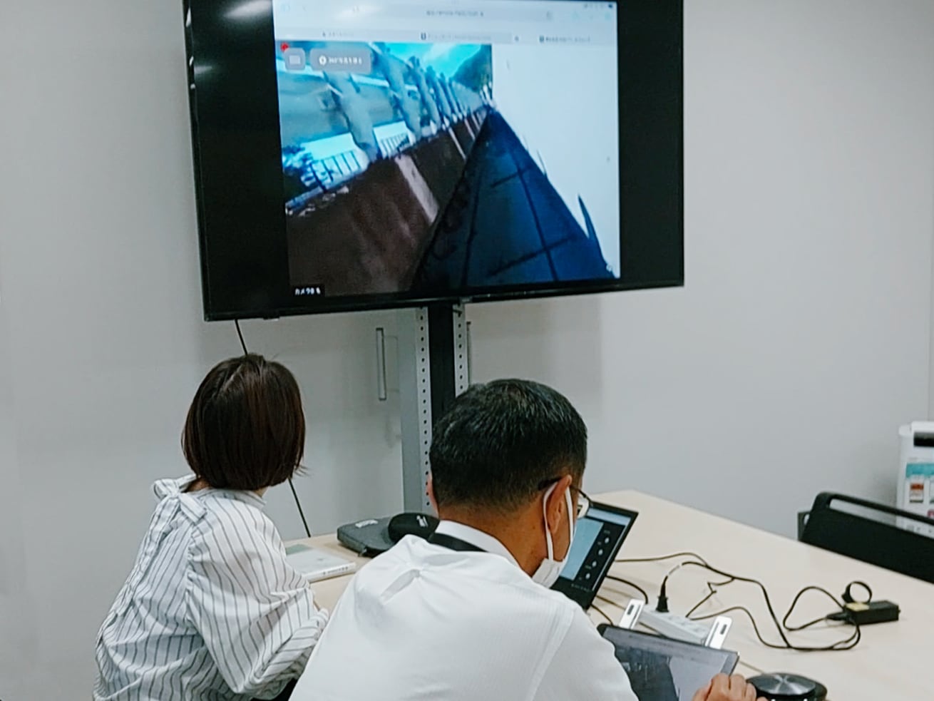 Remote participants watching from Sendai City, while people on the ground in Shiraishi City conduct a safety patrol with 360° video